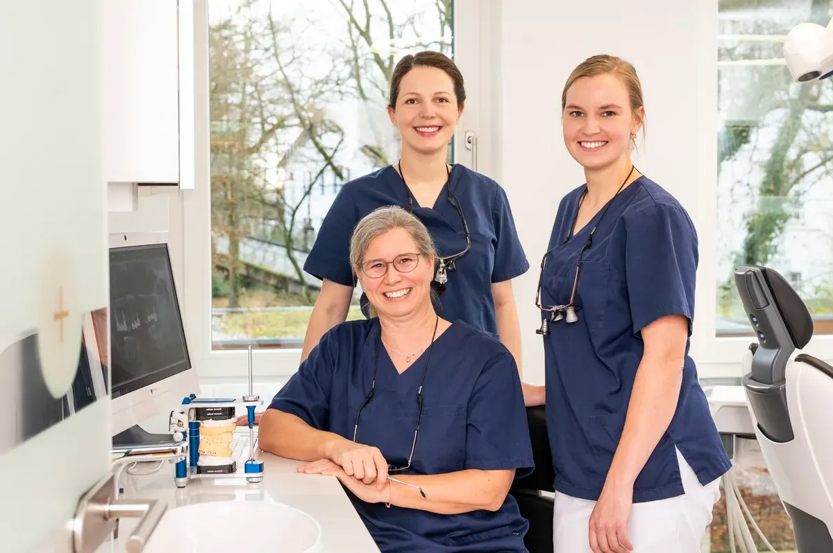 Das Team der Zahnarztpraxis: Zahnärztinnen Juliane Hofschröer, Anna F. Rohling und Laura Wichmann in ihren weißen Kitteln